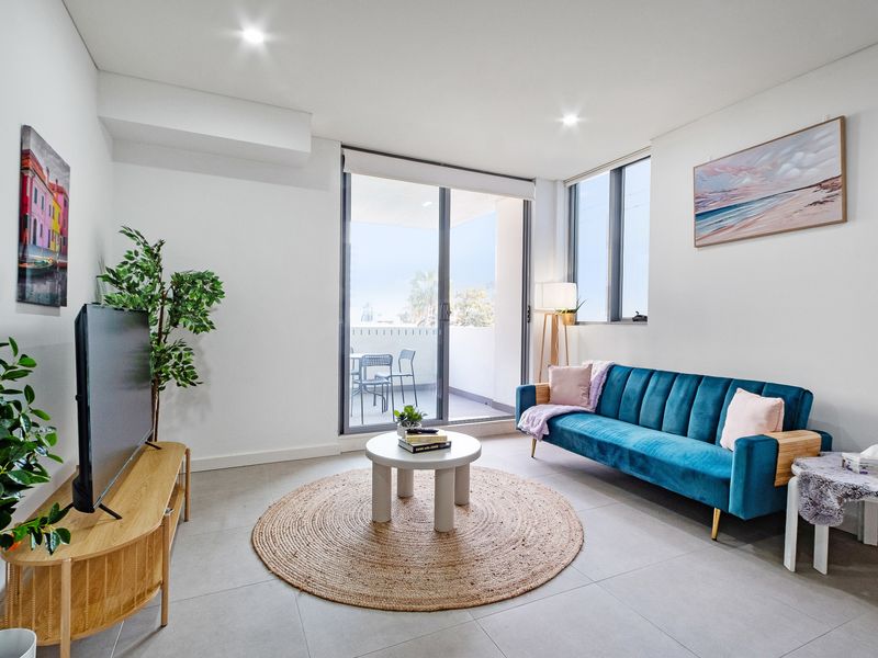 Open-plan lounge with natural light and balcony access.