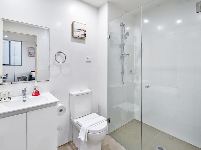 Walk-in shower with glass enclosure.