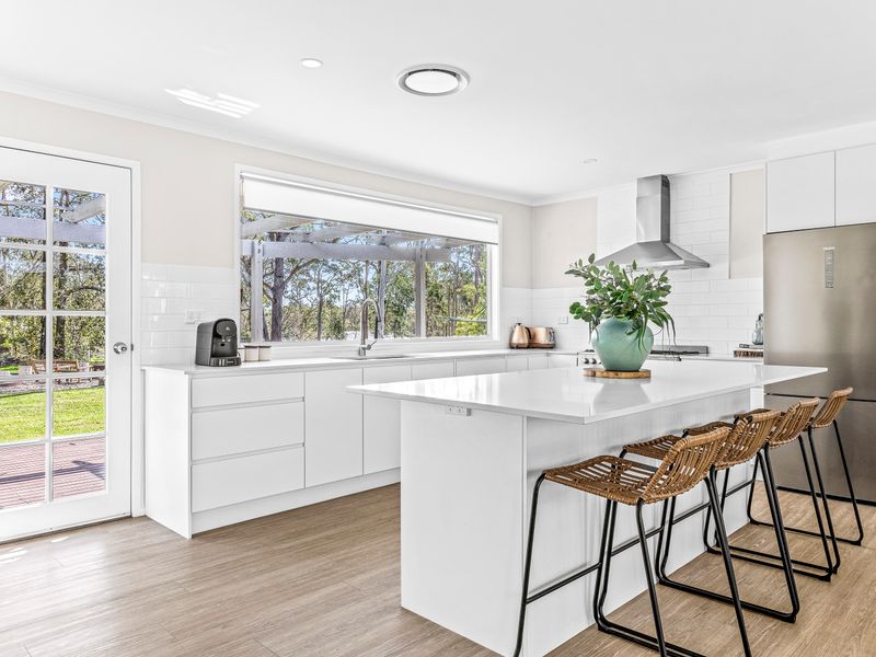 Fully equipped kitchen with island seating and garden views.