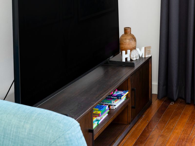 Practical TV setup with extra books for guest enjoyment.