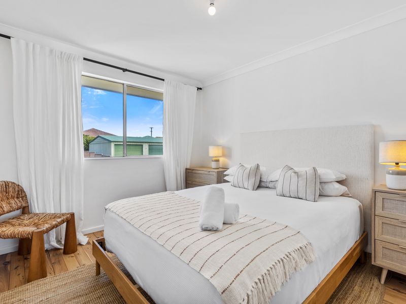 Cozy bedroom with soft tones, natural light, and plush bedding