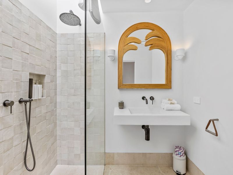 Modern ensuite with curved mirror and contemporary vibe