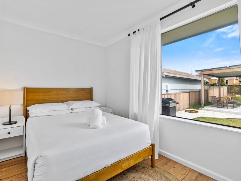 Sunlit guest room with crisp linens and peaceful garden views