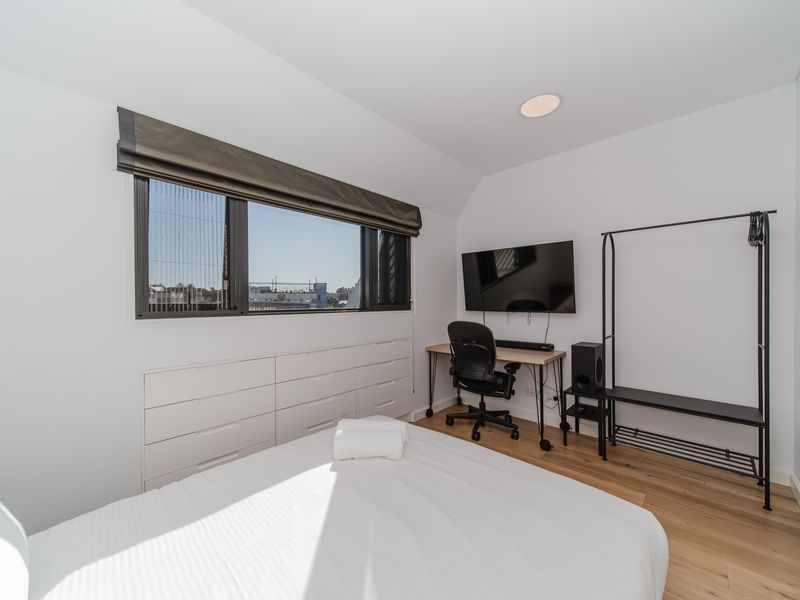 Bedroom with storage, workspace and TV.