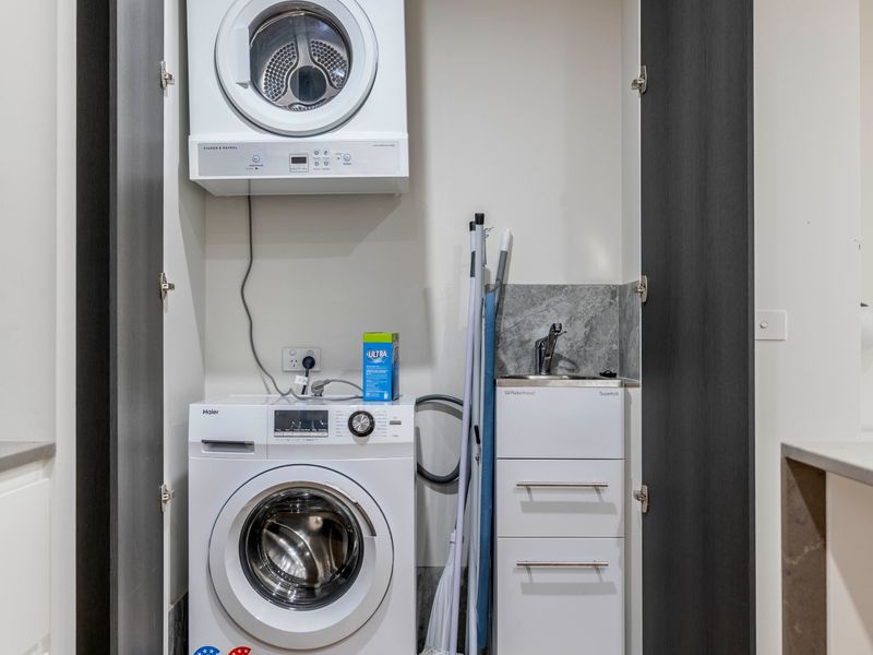 European-style laundry with washer, dryer, and storage space