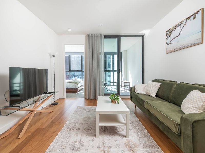 Contemporary living room with balcony access and timber floors