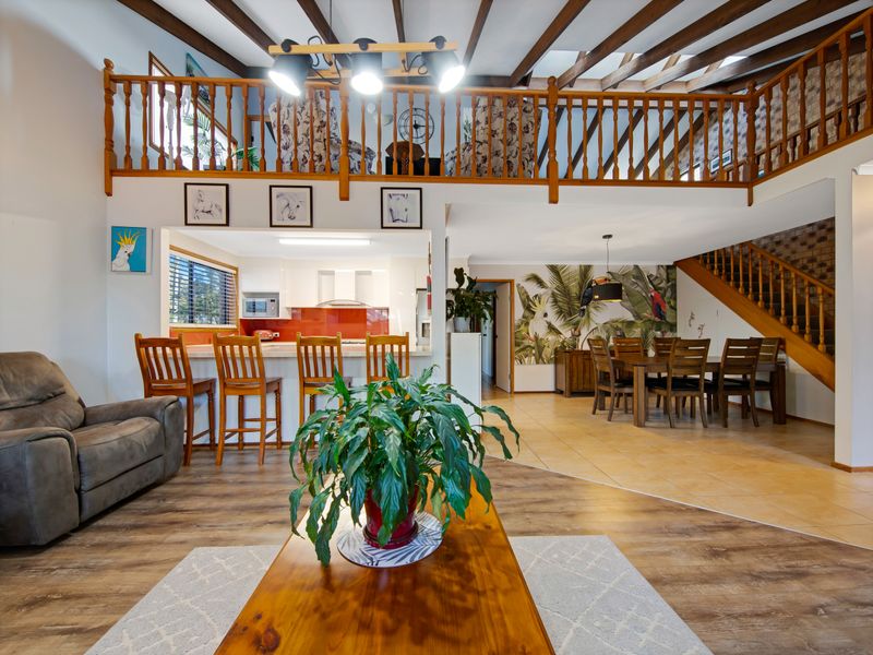 Bright and airy home featuring a cozy lounge, dining area, and loft view.