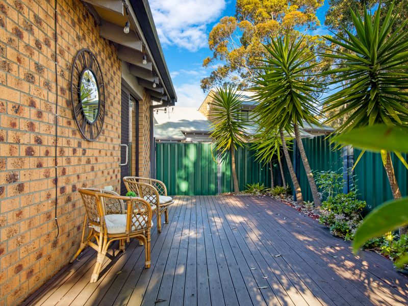 Relaxing outdoor deck with cozy seating surrounded by greenery.