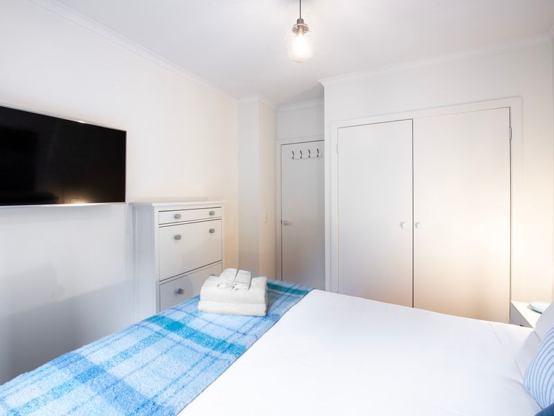 Light-filled bedroom with TV