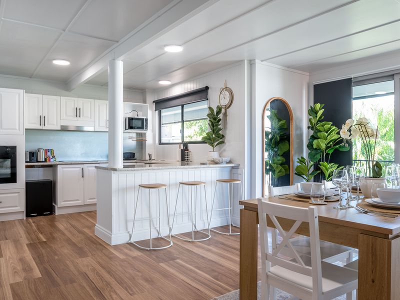 Open-plan kitchen and dining area with breakfast bar, modern appliances, and stylish decor