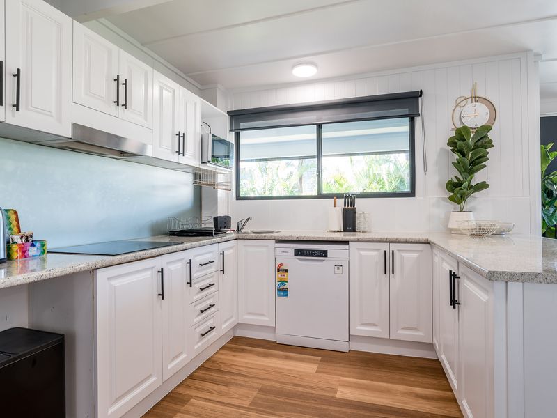 Bright kitchen with large windows, white cabinetry, and open layout