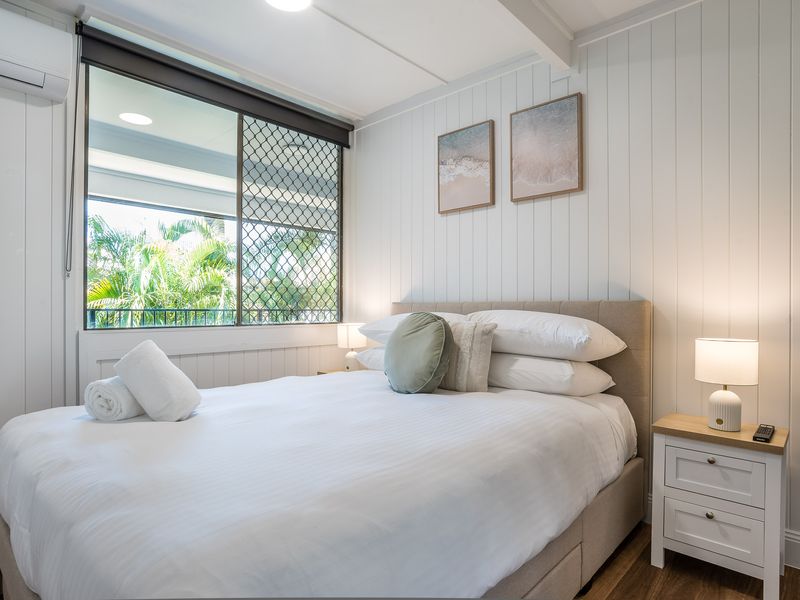 Bright bedroom with queen bed, large window, and natural light