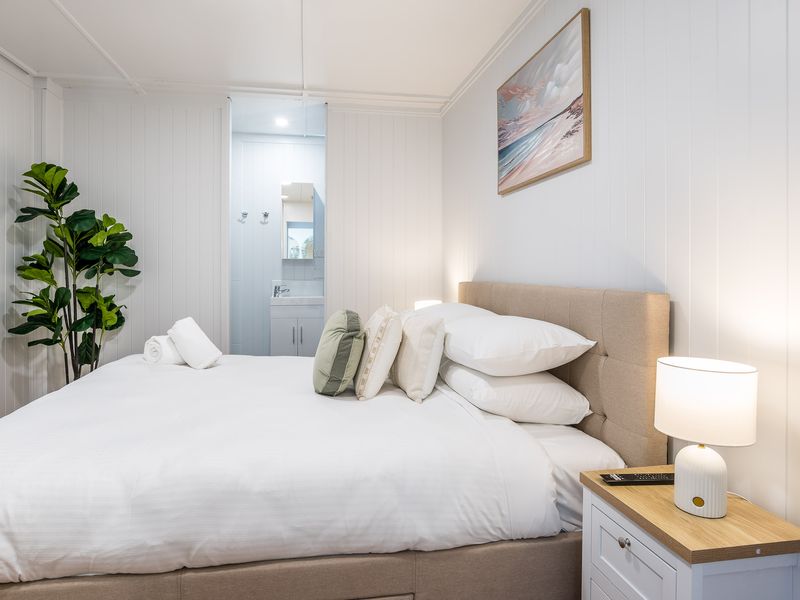 Inviting bedroom with queen bed, indoor plants, and natural tones