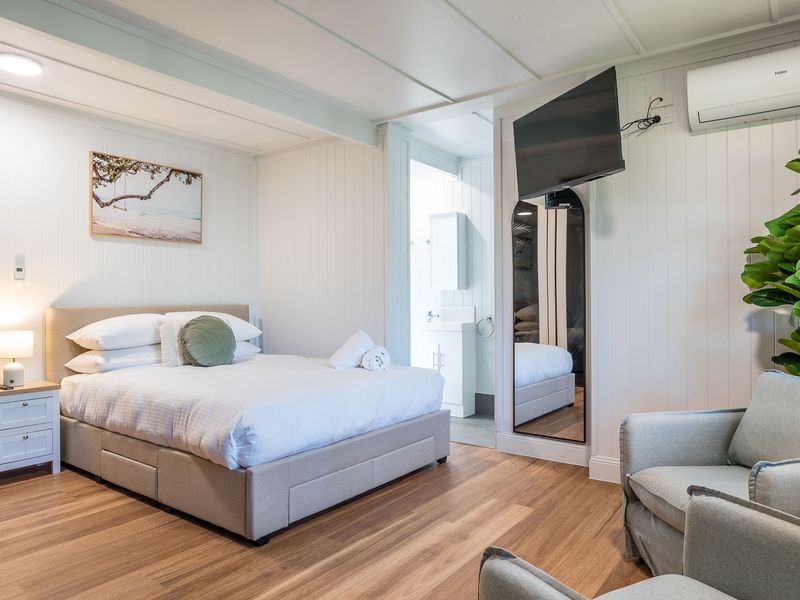 Bedroom with queen bed, TV, and air conditioning for comfort