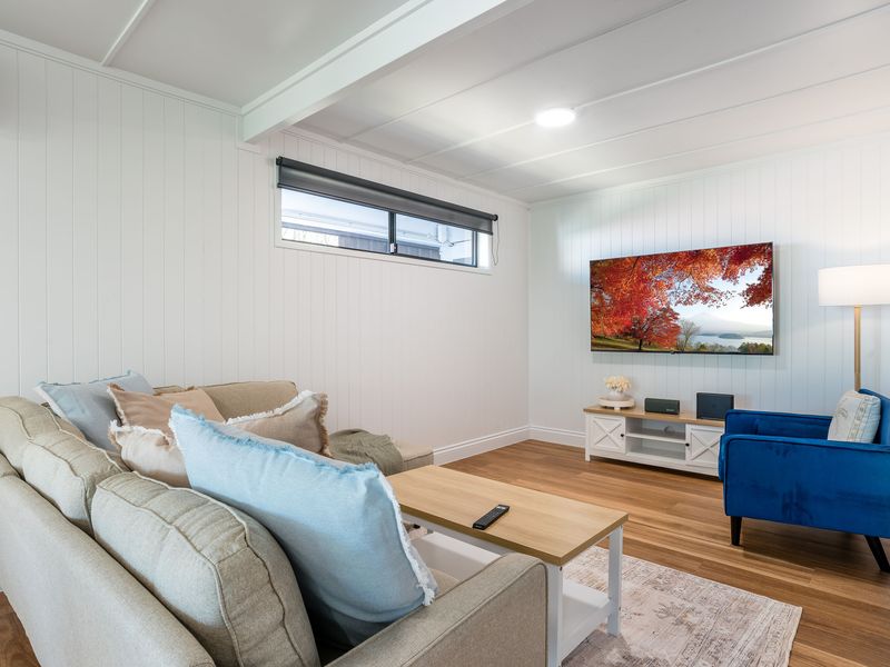 Spacious living room with comfortable sofa, armchair, and flat-screen TV