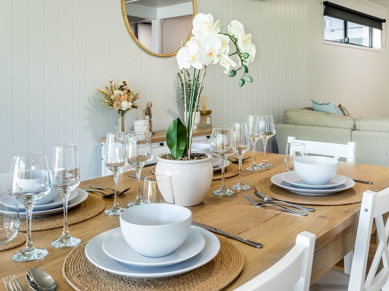 Dining area with set table, glassware, and floral centerpiece