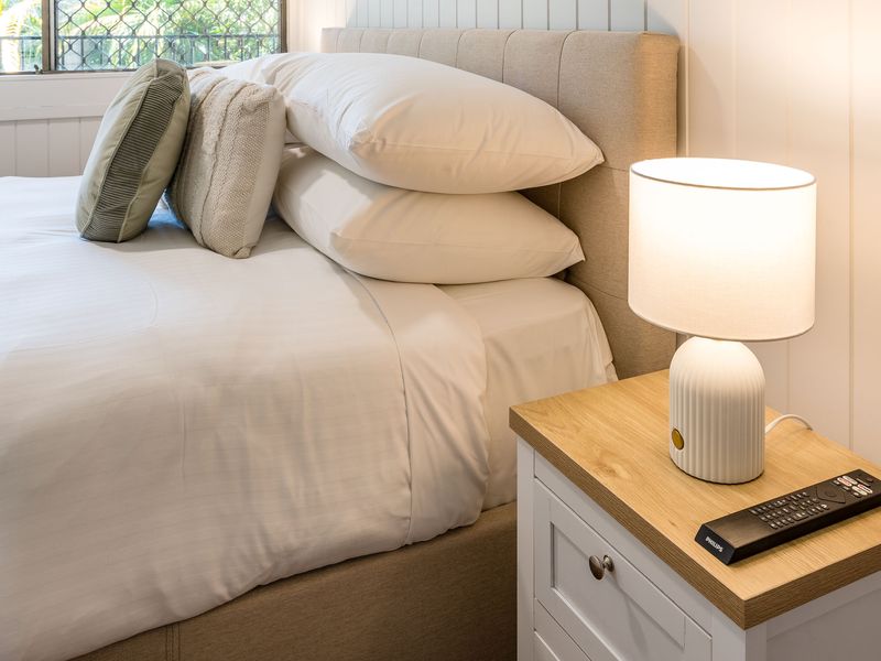 Stylish bedside setup with lamp and fresh linens for a relaxing stay