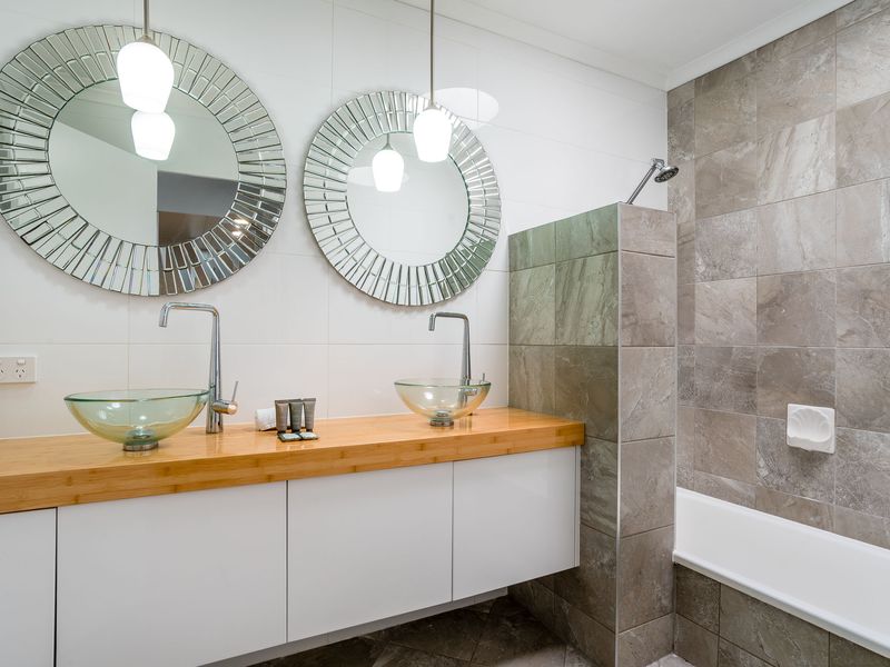 Spacious bathroom with double vanity, mirrors, and modern fixtures