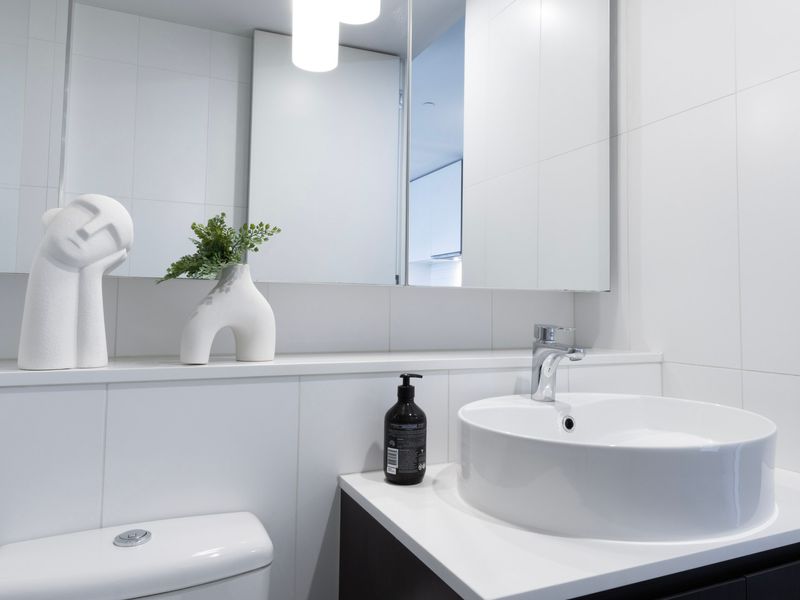 White vanity with decorative accents and mirror storage