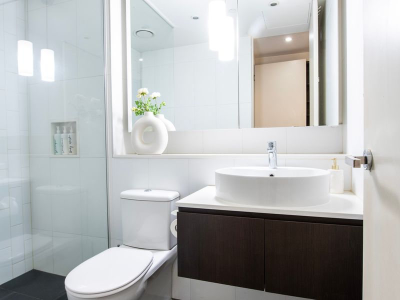 Modern bathroom with vanity, mirror, and bright lighting