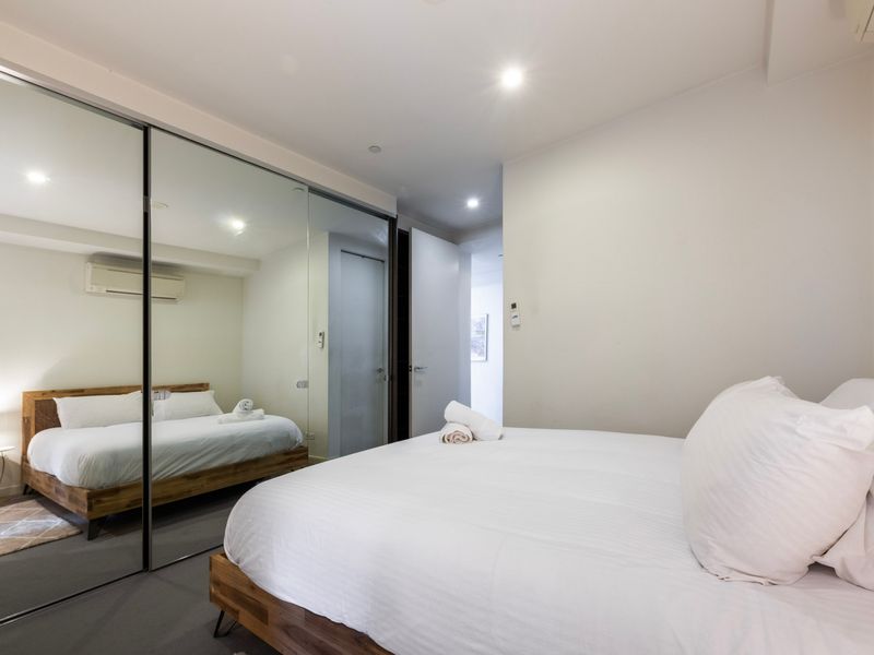 Bedroom with mirrored wardrobes and soft lighting