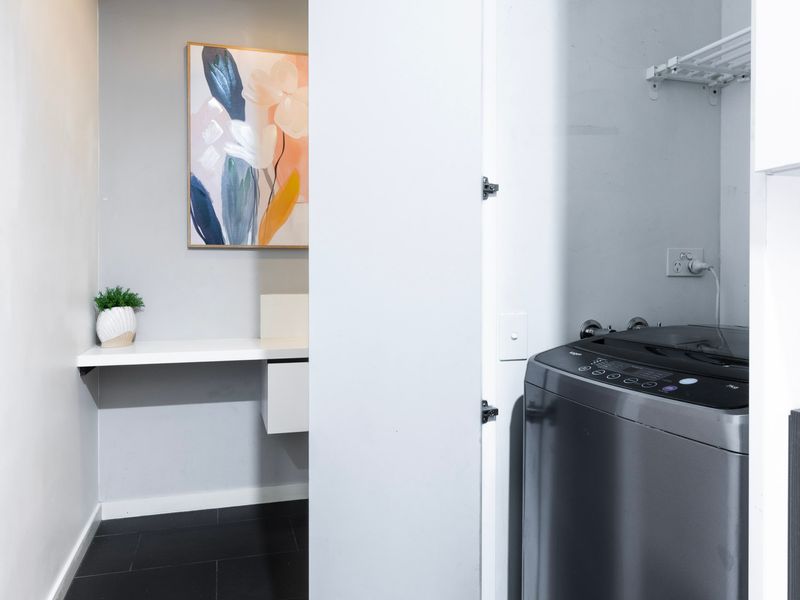 Laundry area with washer and storage space