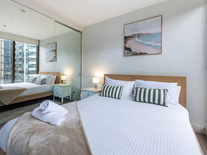 Bedroom with mirrored wardrobe and queen bed