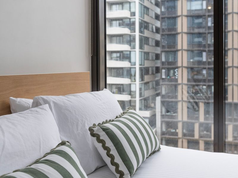 Comfortable bed with striped pillows and natural light