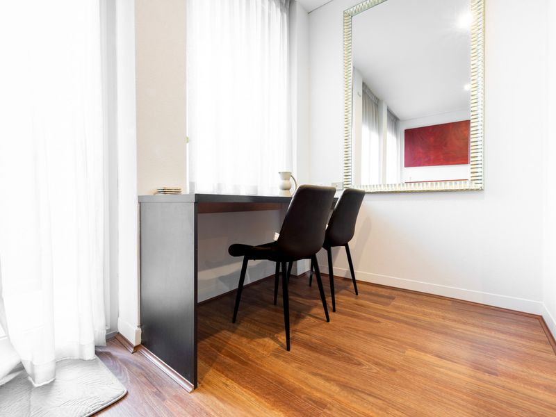 Dining corner with chairs, desk-style table, and large mirror