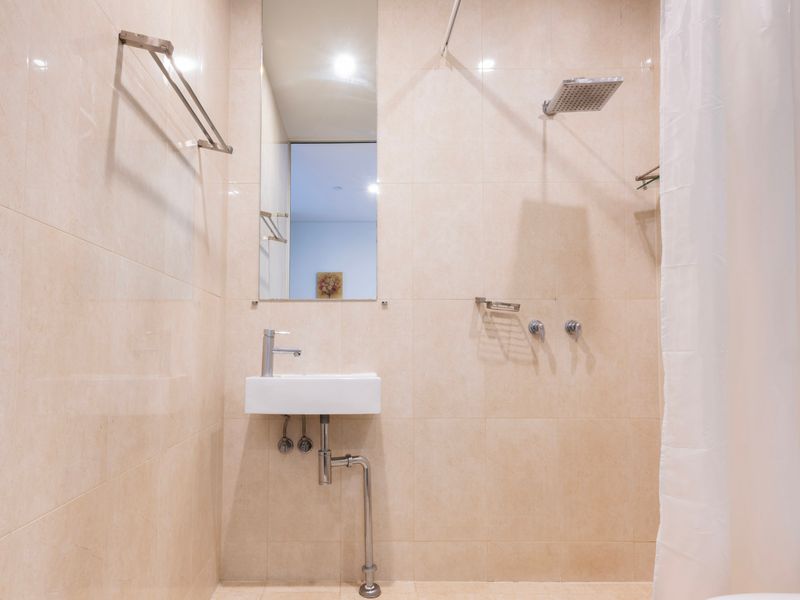 Bathroom with shower, sink, and tiled walls