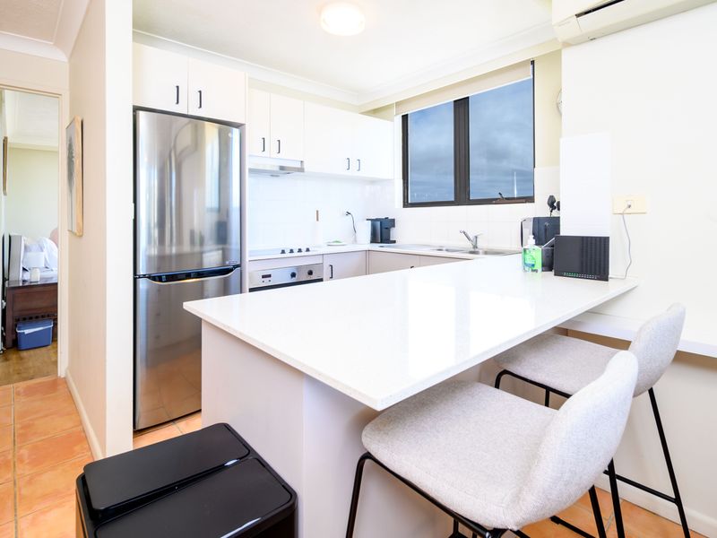 Bright and modern kitchen with breakfast bar and stainless steel appliances.