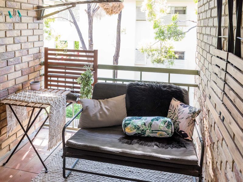 Private balcony corner with comfortable seating and brick surrounds