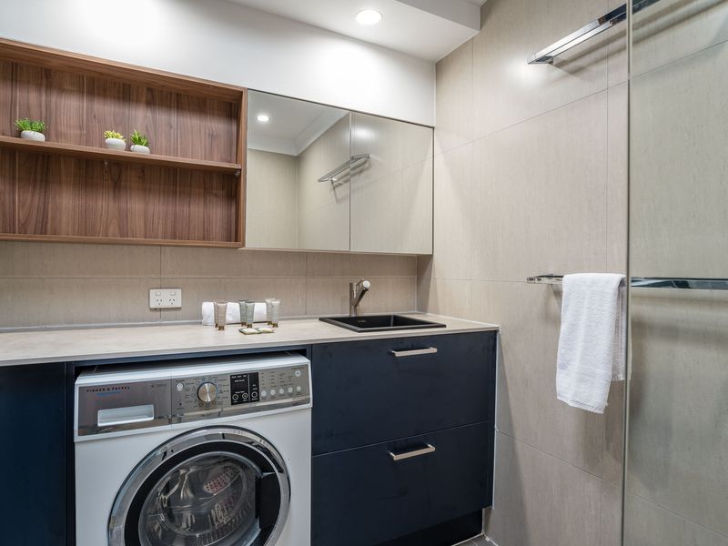 Laundry nook with washing machine, cabinetry, and bench space