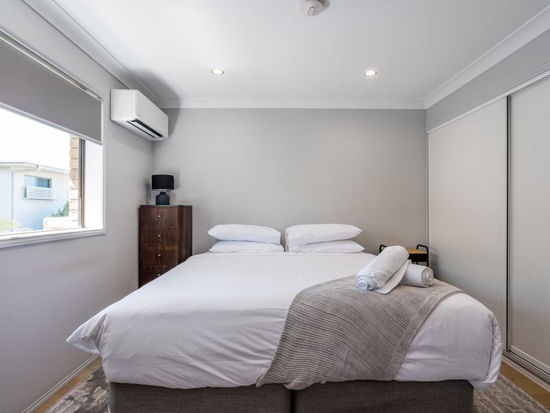 Comfortable bedroom with king bed, air-conditioning, and built-in wardrobe