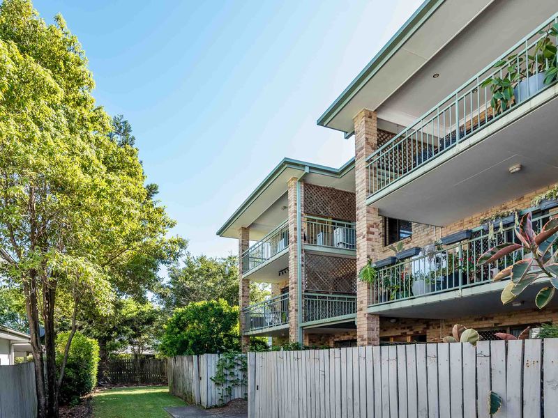 Exterior view of the apartment building with private balconies and leafy surroundings