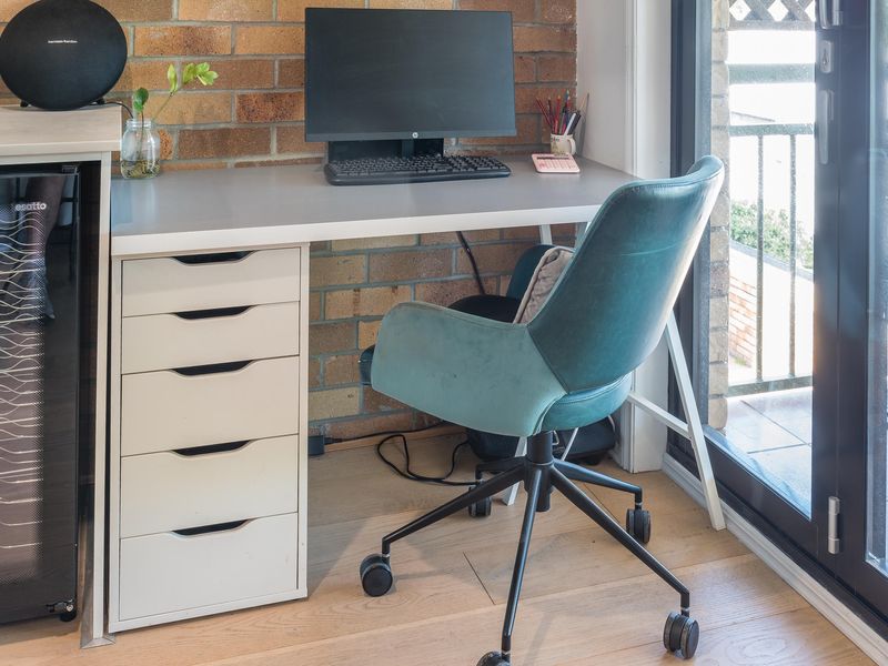 Dedicated workspace with desk, office chair, and balcony access