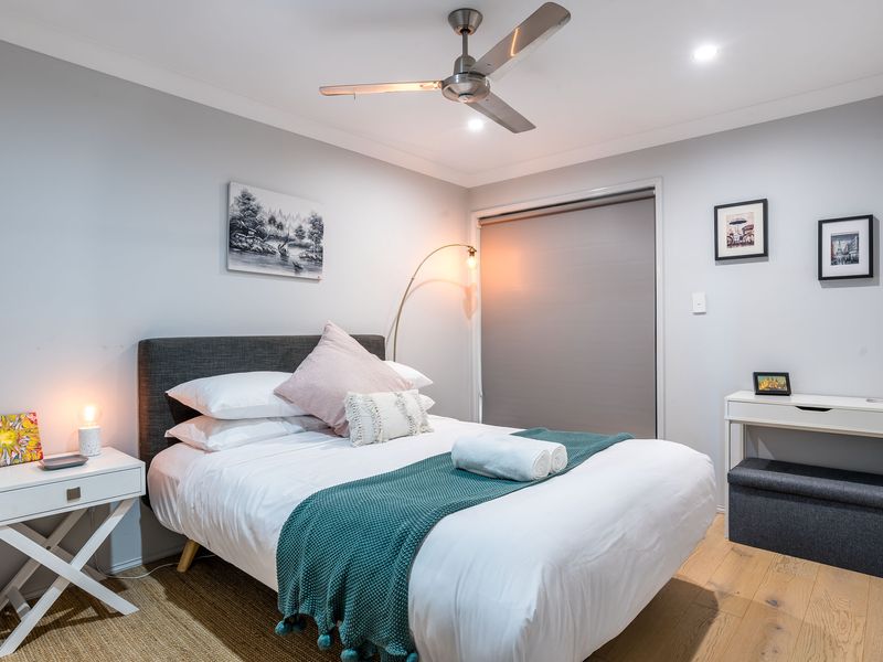 Stylish bedroom with queen bed, soft lighting, and fresh hotel-quality linen