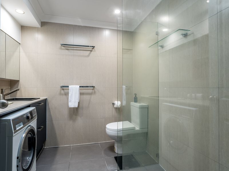 Spacious bathroom with shower, toilet, and laundry area