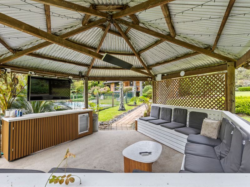Covered outdoor pavilion with lounge seating and BBQ area