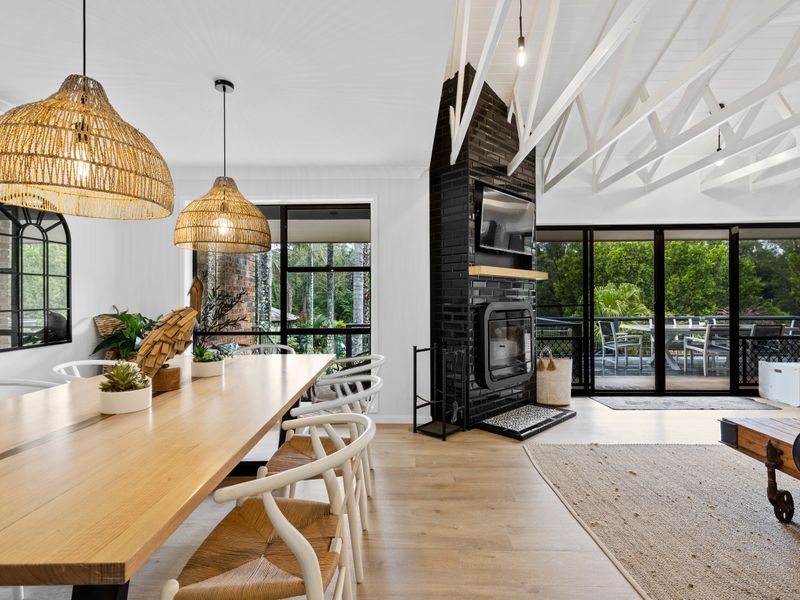 Designer dining area with long timber table and warm lighting