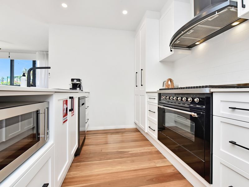 Sleek kitchen with quality appliances and timber floors
