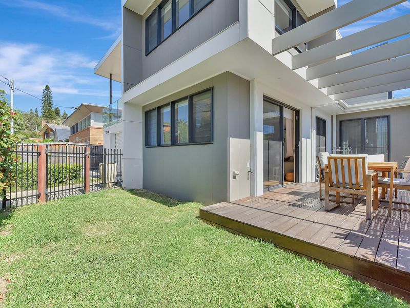 Sunny backyard with outdoor dining and garden views