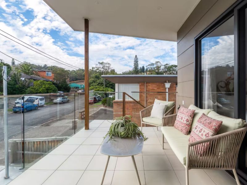 Outdoor balcony seating with cozy chairs and table