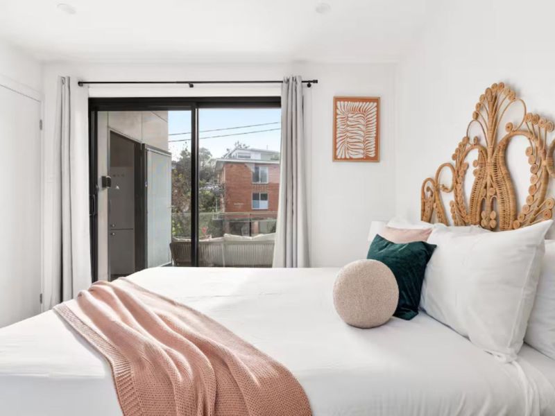 Stylish bedroom featuring mirrored wardrobe and natural light