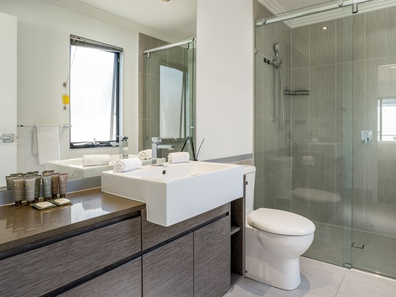 Bathroom with vanity, mirror, and walk-in shower.