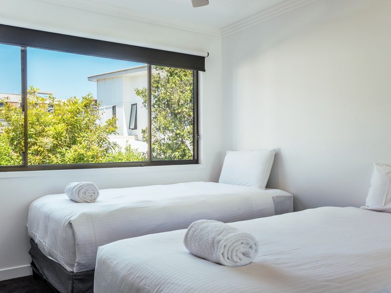 Twin bedroom with large window and natural light.