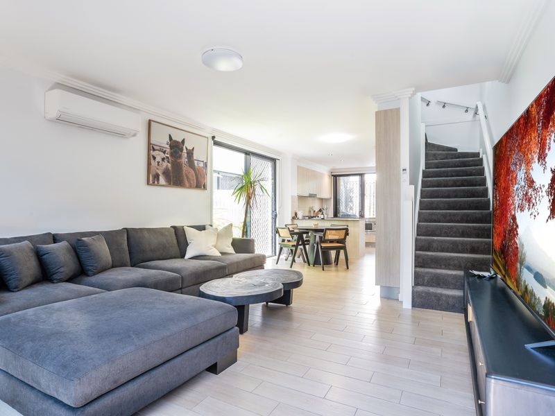 Open-plan living and dining area with large sectional sofa.