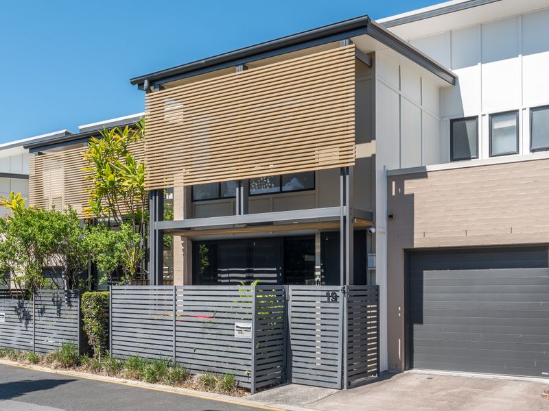 Exterior view of townhouse with secure garage and gated entry.
