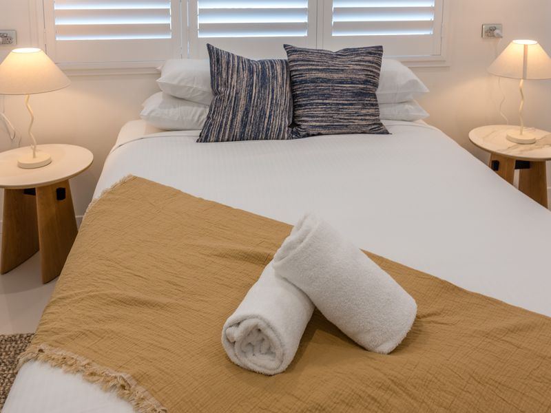 Cozy bedroom with warm lighting and soft tones.