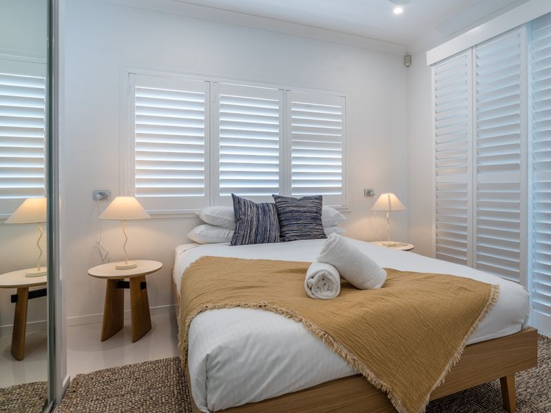 Cozy bedroom featuring soft linens and warm lighting.